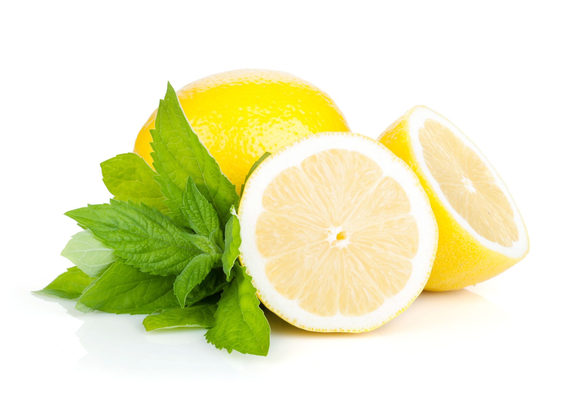 One cut and uncut lemon with mint against a white background